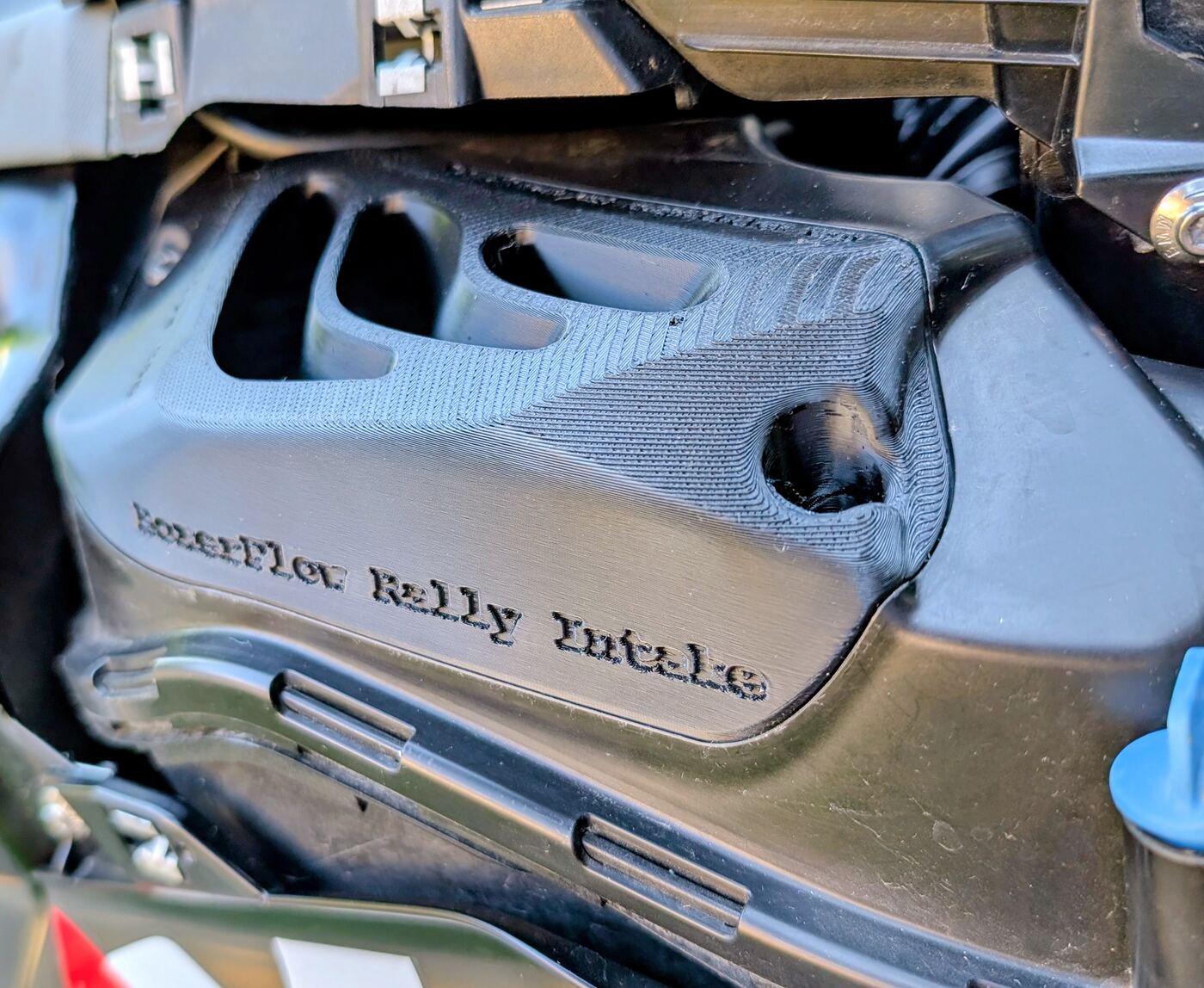 Detail of the engraved BoxerFlow Rally Intake lettering on the face of an installed intake cover on a BMW R 1300 GS.