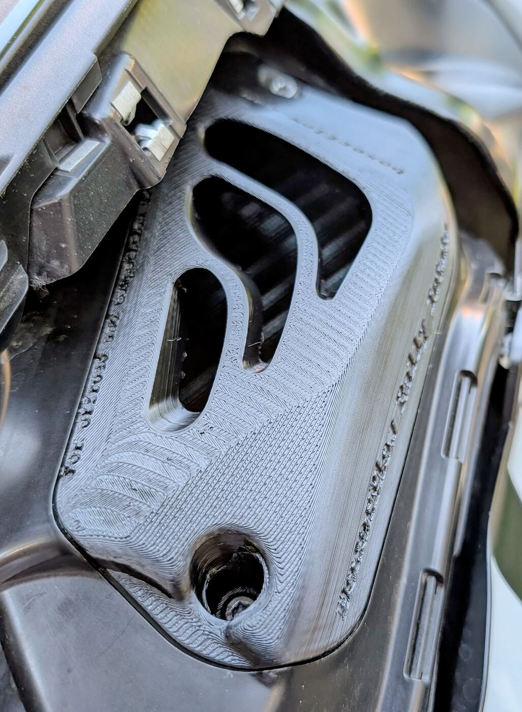 Close-up of the open intake slots on a BoxerFlow Rally Intake cover fitted to a BMW R 1300 GS, with the airbox visible through the openings.
